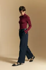 Pantalón de vestir negro con corte recto y tiro medio-alto, confeccionado con líneas sastreras limpias y bolsillos laterales.