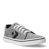 Championes Converse modelo Distrito de caña baja, confeccionados en lona color gris. Presentan el icónico logo de estrella y chevron en negro en el lateral, cordones blancos y suela de goma blanca con una línea negra decorativa.