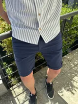 Bermuda de gabardina color azul marino, de corte clásico y con dobladillo en el bajo.