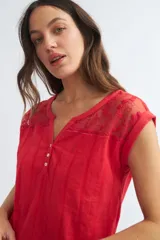 Blusa roja de algodón con cuello en V y detalle de encaje floral en el canesú.