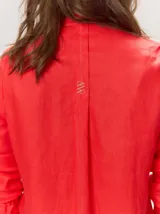 Camisa de lino liviano color tostado, con silueta relajada, cuello mao, alforzas verticales frontales, mangas con volumen y puños elastizados con volados.