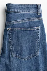 Jean wide leg de tiro alto en denim de algodón con leve elasticidad. Presenta diseño de cinco bolsillos, presillas para cinturón y cierre frontal con botón metálico.