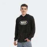 Canguro con capucha de estilo urbano, color negro con efecto lavado. Presenta un estampado gráfico central con el logo de la marca Reef enmarcado en un óvalo con líneas azules y amarillas, y cuenta con un bolsillo frontal tipo canguro.