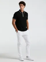 Polo negra de piqué con vivos blancos en cuello y mangas, calce slim fit y logo bordado en el pecho.