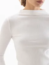 Polera blanca de tejido acanalado, con cuello alto y mangas largas ajustadas.