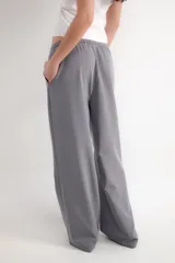 Pantalón negro de corte wide leg, con cintura elástica ajustable mediante cordón y bolsillos frontales.