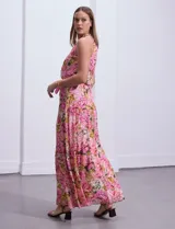 Vestido largo de gasa estampada con flores rosas, amarillas y verdes, marca Julia Jordan. Tiene escote halter, cintura elastizada con lazo de ajuste, abertura en la espalda con botones y forro interno a tono.