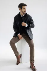 Campera de cuero negro con cuello y puños de piel sintética.