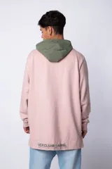 Buzo tipo canguro con capucha, confeccionado en una combinación de algodón rústico y microfibra. Presenta un diseño bicolor en tonos rosado y verde militar, con bolsillo frontal tipo canguro en contraste, cordones ajustables y estampa personalizada en el frente.