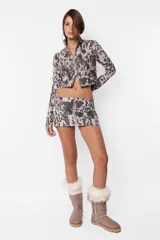 Minifalda de sarga gamuzada con estampado animal print, cierre frontal metálico y recortes horizontales con cierres laterales.