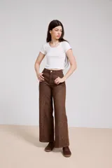 Pantalon de jean azul de corte ancho, con paneles laterales estampados con diseño floral sutil y costuras visibles.