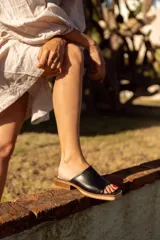 Sandalias negras de cuero con base de madera.