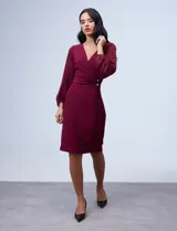 Vestido azul de RM Richards en seda fría, con escote en V cruzado, cintura drapeada, mangas largas de gasa y aplique de botones en el lateral.