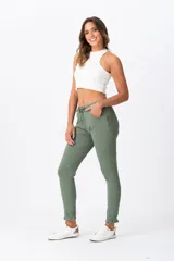 Pantalón largo verde, súper elastizado, con pretina elastizada, cinturón de lazo y costura transversal a la altura del muslo.