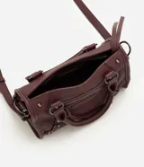 Cartera satchel Satinato de color negro, confeccionada en poliuretano. Cuenta con asas de mano fijas, correa larga removible, bolsillos frontales con cierre, tachas metálicas decorativas y tiras colgantes.