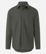 Camisa de manga larga confeccionada en tricolina de algodón, con cuello inglés, cierre frontal de botones y puños abotonados. Diseño liso y versátil.