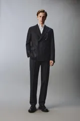 Blazer de corte regular fit confeccionado en lana italiana, con diseño de raya diplomática. Presenta cuello con solapas de pico, cierre frontal de botonadura cruzada, bolsillos de vivo en el pecho y bolsillos de solapa en la cadera.