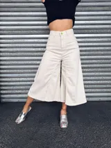 Pantalón capri color crudo, de tiro alto, pierna ancha y largo midi.