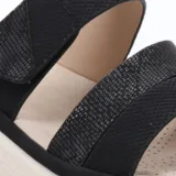Sandalias de plataforma baja con dos tiras anchas en el empeine, una de ellas con ajuste de velcro. Presentan una combinación de texturas en tonos beige y detalles metalizados, con plantilla acolchada y suela de goma blanca.