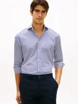 Camisa de manga larga de Tommy Hilfiger, con diseño de rayas verticales azules y blancas, cuello rígido y cierre frontal con botones.