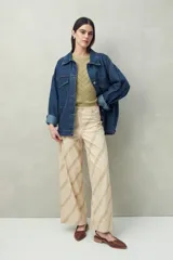 Pantalón ancho de algodón con calce relajado, color beige con estampado de rayas diagonales en verde. Cuenta con bolsillos de parche y tiro medio.