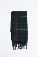 Bufanda de estilo escocés con diseño de cuadros en tonos verde, azul y líneas finas en rojo. Presenta flecos en los extremos y una etiqueta pequeña de la marca.