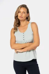 Musculosa blanca sin mangas, de corte clásico y calce cómodo, confeccionada en tejido suave. Presenta escote redondo, cartera con botones frontales y un pequeño bolsillo aplicado en el pecho.