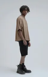 Remera de manga corta con calce extra oversize, color marrón chocolate con efecto gastado/deslavado. Presenta un corte con recortes horizontales en el frente y la espalda, y cuello redondo con terminación deshilachada.