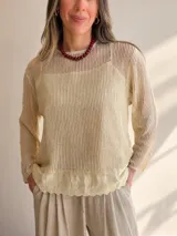 Tejido liviano de punto calado en color beige con una musculosa básica incorporada del mismo tono, de manga larga y calce relajado.