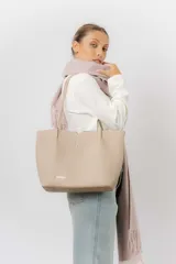 Cartera tipo tote de diseño amplio y estructurado, confeccionada en material sintético con textura graneada. Cuenta con doble asa larga para llevar al hombro y logo de la marca aplicado en el frente.