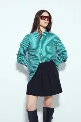 Minifalda tableada de color negro, con diseño de tablas anchas que aportan volumen y movimiento. Presenta un corte estructurado y un calce cómodo.