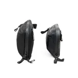 Riñonera negra con correa ajustable para usar como bandolera. Fabricada con material xPac X21 impermeable, cuenta con apertura de 180°, 7 bolsillos internos, 2 bolsillos externos, detalles en color ladrillo y cierres impermeables.