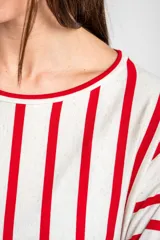 Remeron de corte oversize con cuello redondo y mangas largas. Presenta un diseño de rayas verticales en color rojo sobre base color crema.