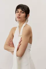 Vestido largo negro de corte al cuerpo con cuello halter y detalle de hebilla metálica dorada en el hombro con tira drapeada.