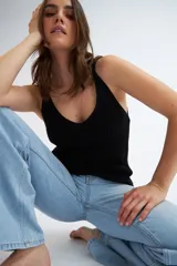 Top tejido negro con escote en V y tirantes finos.