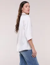 Camisa de satén azul marino con cuello mao, escote en V y mangas tres cuartos con hombro caído. Presenta silueta holgada, cierre frontal con botones y ruedo asimétrico.