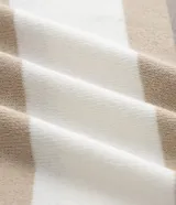 Suéter de punto con cuello redondo y manga larga, diseñado con un patrón de bloques de color en tonos beige, blanco y gris. Presenta un corte regular que se ajusta de forma anatómica al cuerpo.