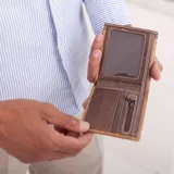 Billetera color beige de símil cuero lisa con galón elastizado marrón con línea blanca. Interior con doble repartición para billetes, visor y tarjeteros.