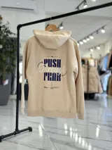 Canguro oversize de color beige con capucha y estampado en la espalda que dice "PUSH Through FEAR".