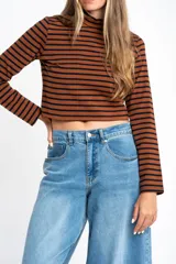 Polera de manga larga, corte ajustado al cuerpo, con cuello alto. Presenta un estampado de rayas horizontales en tonos marrón camel y azul marino.