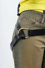 Cinto de cuero flexible color negro, envolvente y ajustable mediante hebilla metálica dorada de diseño atípico que permite anudarlo con libertad.