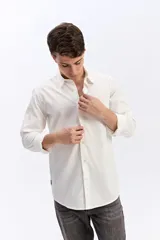 Camisa de manga larga color gris oscuro, confeccionada en tejido liviano con textura sutil, cuello tradicional y cierre frontal de botones.