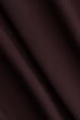 Pollera tobillera color marrón chocolate, de punto con elástico oculto en la cintura y frunces a la altura de la cadera para crear una silueta levemente drapeada.