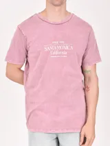 Remera color beige con estampa rectangular con diseño abstracto en tonos marrones y texto.