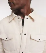 Campera puffer de terciopelo cotele color crema, con cuello inglés, manga larga, abotonado delantero y bolsillos de solapa en el pecho.