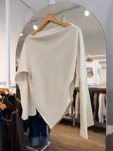 Sweater de tejido de punto color marrón chocolate, con diseño asimétrico de corte en pico, cuello amplio tipo buche y mangas largas con puños ajustados.