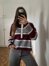 Sweater de punto bremer a rayas horizontales en tonos bordó, gris y blanco, con cuello polo blanco y cierre frontal parcial con botones.