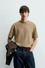 Camiseta de corte relajado con cuello redondo y manga corta, confeccionada en tejido de algodón liso.