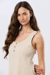 Musculosa de algodón color beige melange, con escote redondo, cierre frontal parcial con botones oscuros y tirantes decorados con volados sutiles.