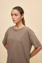 Remera negra de calce amplio, confeccionada en algodón liviano, con cuello redondo, mangas cortas y hombros levemente caídos.